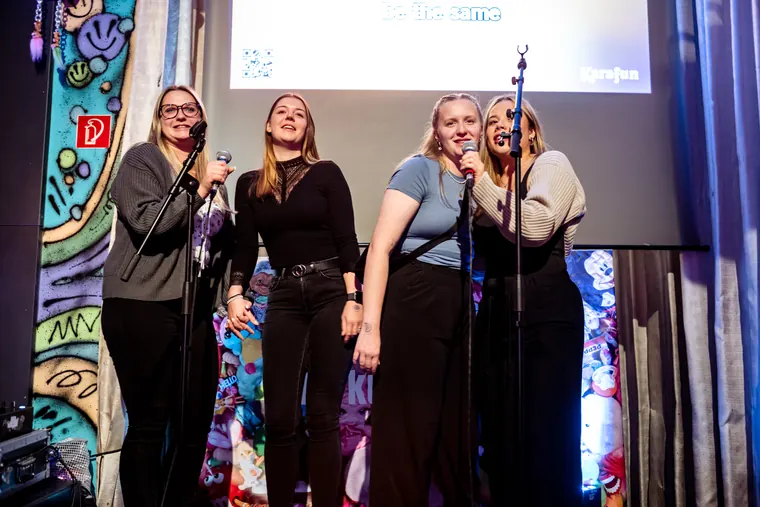 Four women singing together