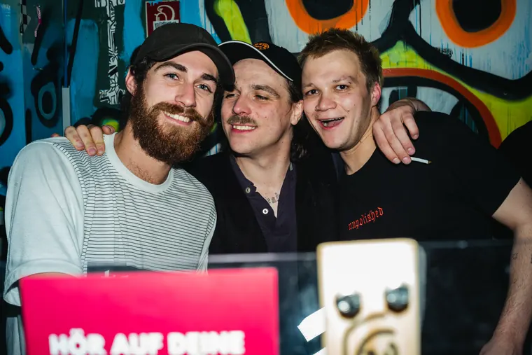 Three friends laughing at the DJ booth