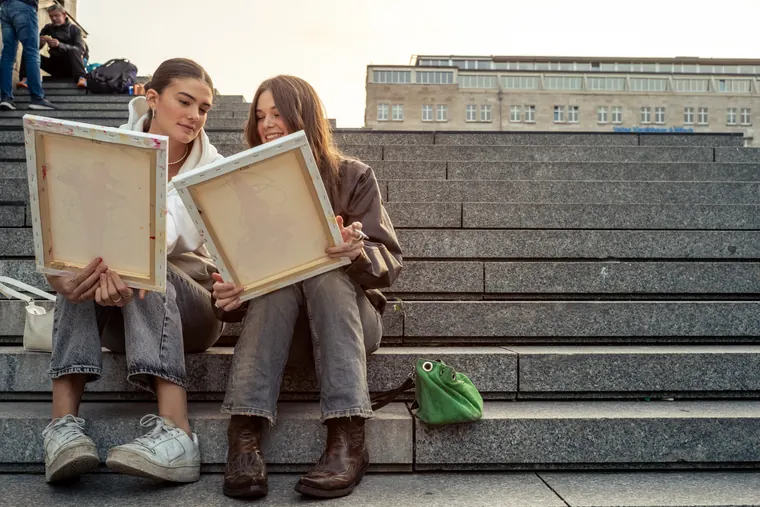 Two guests with canvases on the cathedral steps